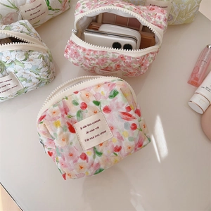 Detailed view of floral quilted cotton makeup bags with a secure zipper closure