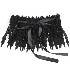 Detail of black lace corset belt with satin bow and intricate feather-like patterns
