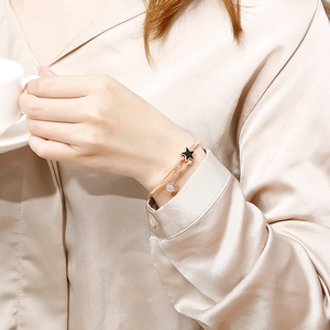Rose gold stainless steel open bangle featuring black enamel and crystal star charms