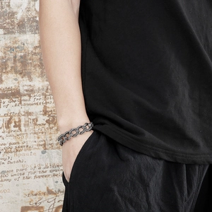 Close-up of retro silver chunky Cuban chain bracelet worn by male model on wrist