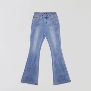Détail du jean évasé bleu clair montrant la braguette et la texture du denim délavé