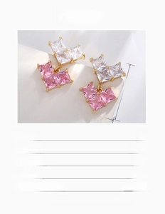 Macro view showing geometric square zircon earrings with pink and clear stones in gold plating