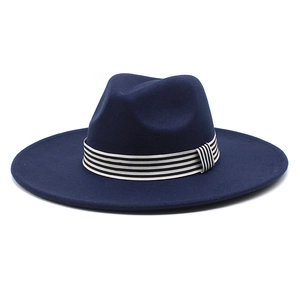 Detail of navy blue wool fedora with a black and white striped ribbon band trim