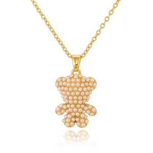 Close-up of a gold necklace featuring a bear pendant fully paved with white pearls