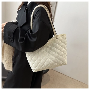 Detail of white quilted tote bag with diamond stitching and soft woven rope handles