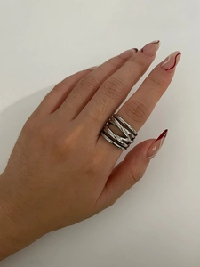 Detailed close-up of a silver multi-layer crisscross ring worn on a finger