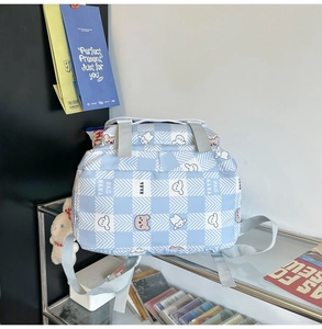 Detail of light blue checkered backpack with cute bear prints and adjustable straps