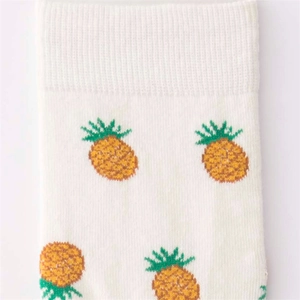Detailed macro view of white cotton street style socks featuring yellow pineapple pattern