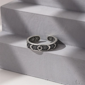 Macro detail of vintage 925 sterling silver ring with moon and flower relief patterns