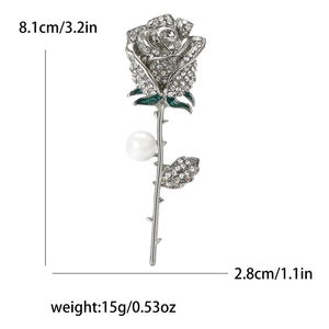 Detailed view of rose brooch with rhinestones, green enamel, and pearl measuring 8.1cm