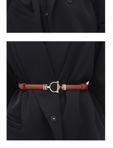 Close-up of caramel leather belt with golden buckle on black blazer for a chic look