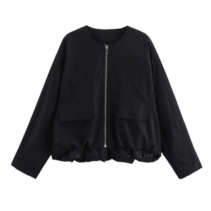 Detail of black flight jacket featuring silver zipper closure and large utility pockets