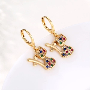 Gold-plated cat-shaped earrings with colorful zircon stones on white ceramic base