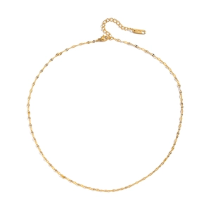 Macro shot of minimalist gold stainless steel fine chain necklace laid in a neat circle