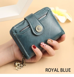 Detail of short royal blue wallet featuring sunflower snap button and clover tassel