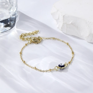 Detail of gold evil eye bracelet showing the lobster clasp and adjustable extension chain