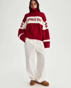 Detail of red and white Apres Ski knit sweater featuring snowflake patterns and high collar