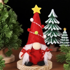 Détail d'un gnome de Noël avec chapeau en sapin rouge, barbe blanche et décorations en feutre
