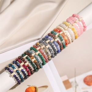 Detail view of colorful agate bead bracelets with carved white rabbit charm on display