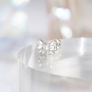 Close-up of S925 sterling silver bow stud earring with central round gemstone detail