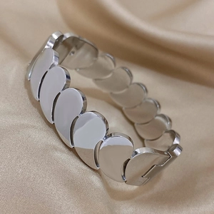 Détail du bracelet multicouche argenté au design de gouttes sur satin doré clair