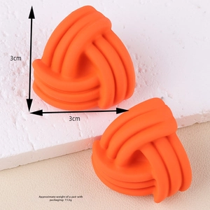 Macro shot of matte orange braided triangle earrings with a textured surface detail