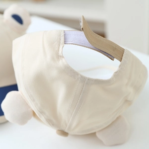 Detail des Klettverschlusses der beigen Kinder-Baseballkappe mit Plüsch-Applikationen