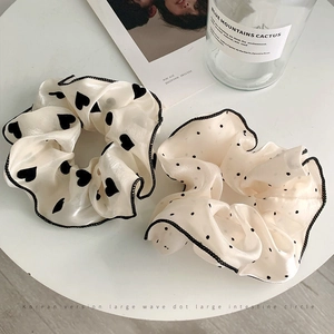 Detail of organza scrunchies set featuring black heart and polka dot patterns