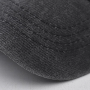 Macro detail of charcoal grey washed cotton baseball cap brim with parallel stitching lines