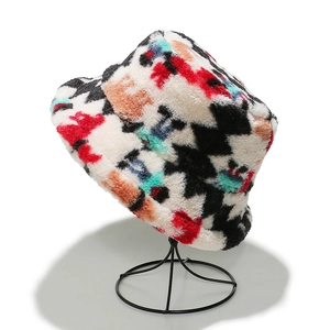Colorful bohemian geometric graffiti faux lamb wool bucket hat on a black metal stand