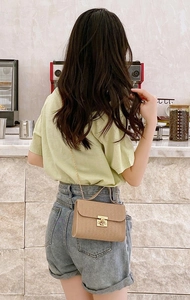 Detail of mocha brown crossbody bag with wave texture and golden chain strap