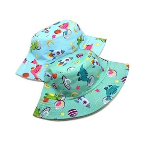 Detail of blue and green kids bucket hats featuring cartoon dinosaur astronaut prints