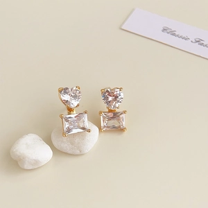Detail showing heart and rectangular zircon stones set in gold earrings on stones