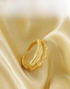 Detailansicht des 18K vergoldeten Bambus-Struktur-Rings auf goldenem Seidenstoff