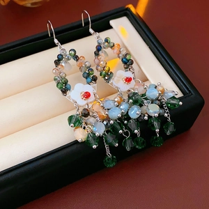Nahaufnahme der böhmischen Ohrringe mit Kristallperlen, Blumen und Metallquasten
