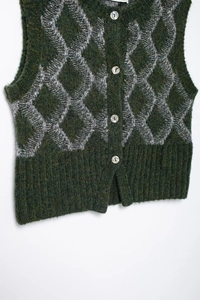 Détails d'un gilet en tricot vert foncé avec motifs à losanges gris et boutons