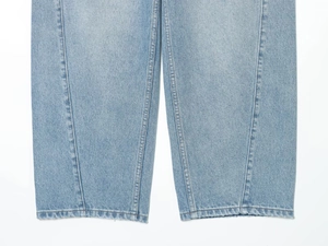 Dettaglio dei jeans denim azzurri con cuciture premium e trama in twill