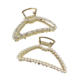 Elegant gold metal shark hair clips with pearls and rhinestones on a white background