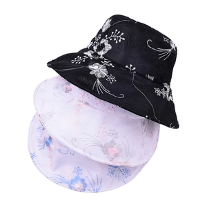 Vista dettagliata di eleganti ricami floreali su cappelli a secchiello in pizzo impilati