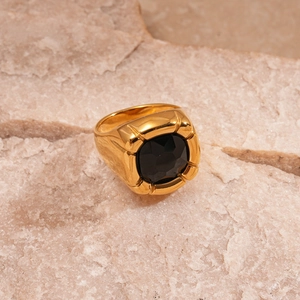 Detail of a vintage gold steel ring with black square zircon on natural brown rock