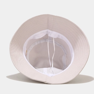 Detail view of cotton bucket hat interior with adjustable strap and white sweatband
