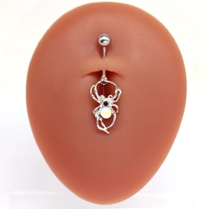 Piercing de nombril araignée en argent avec opale sur un modèle en silicone réaliste