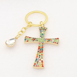 Golden cross keychain with colorful rhinestones and teardrop crystal charm detail