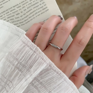 Close-up of silver Mobius ring with Je t'aime engraving worn on hand with ruffled sleeve
