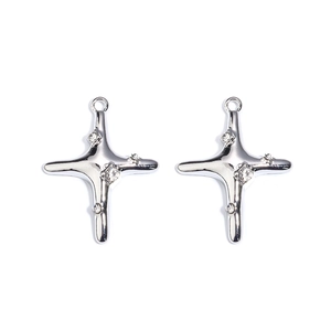 Detailed macro view of silver cross pendants with textured metal and sparkling rhinestones
