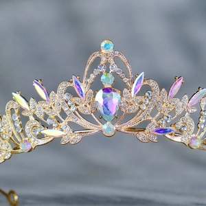 Détail macro de tiare royale dorée avec grand cristal en goutte et filigrane strass