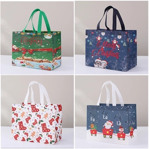 Detail of four colorful non-woven Christmas gift bags featuring snowman and Santa patterns