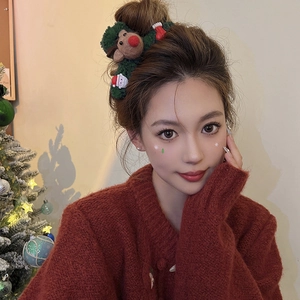 Christmas reindeer hair claw clip featuring green knit and plush Santa festive details