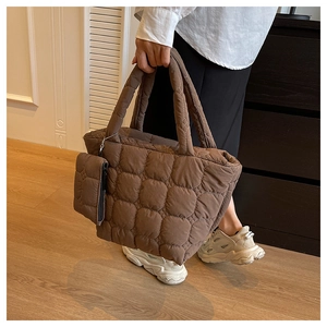 Detailed shot of brown quilted tote bag with circular bubble texture and matching pouch