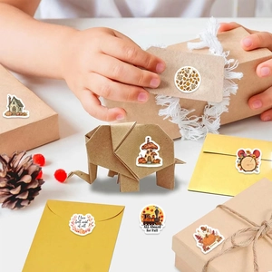 Macro shot of autumn-themed stickers featuring pumpkins and forest animals on envelopes